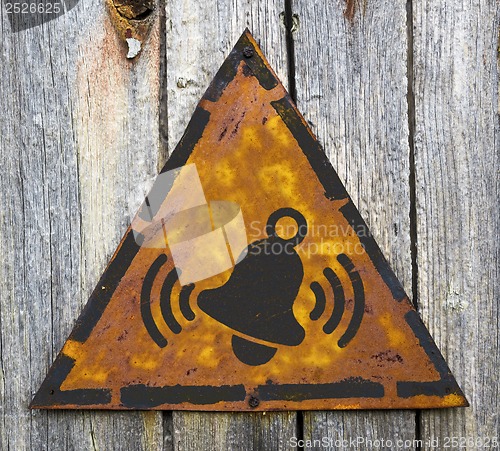 Image of Ringing Bell Icon on Rusty Warning Sign.