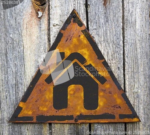 Image of Home Icon on Rusty Warning Sign.