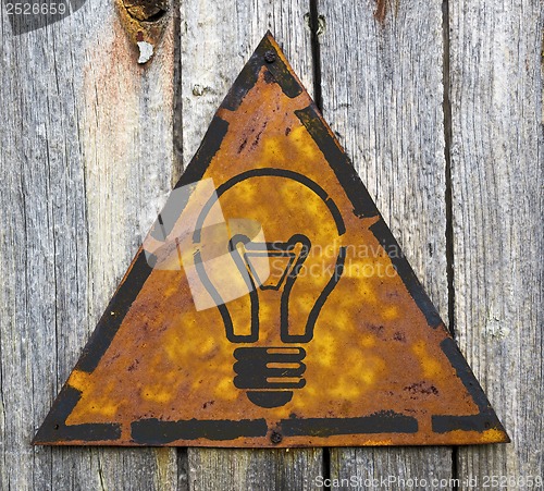 Image of Light Bulb Icon on Rusty Warning Sign.