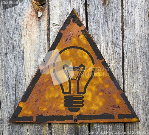 Image of Light Bulb Icon on Rusty Warning Sign.
