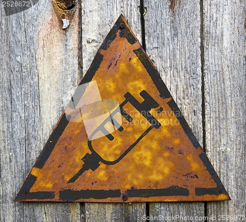 Image of Syringe Icon on Rusty Warning Sign.