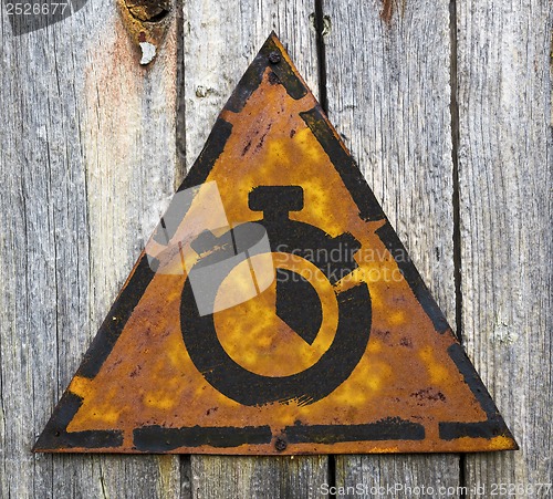 Image of Stopwatch Icon on Rusty Warning Sign.