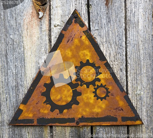 Image of Cogwheel Gear Icon on Rusty Warning Sign.