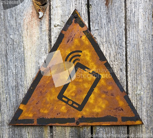 Image of Smartphone Icon on Rusty Warning Sign.