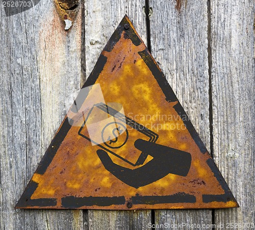 Image of Icon of Money in the Hand on Rusty Warning Sign.
