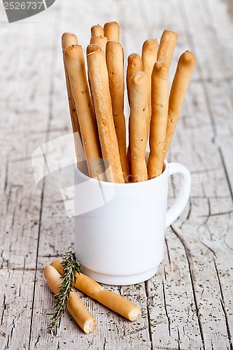 Image of cup with bread sticks grissini and rosemary