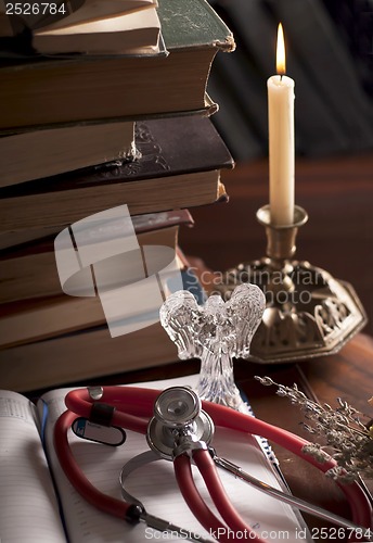 Image of stethoscope, cup of tea, books, candle. Still life