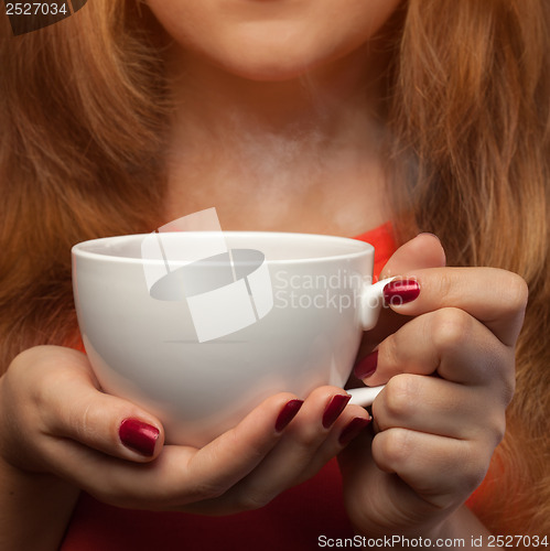 Image of woman holding hot cup