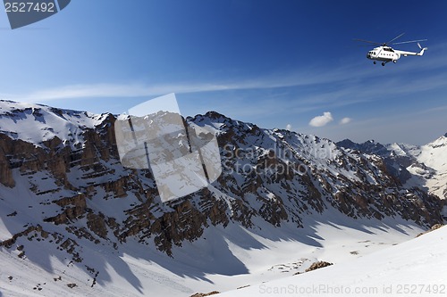 Image of Helicopter in snowy sunny mountains