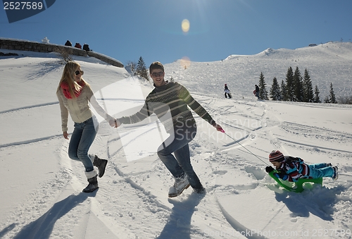 Image of family having fun on fresh snow at winter vacation