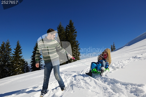 Image of family having fun on fresh snow at winter vacation