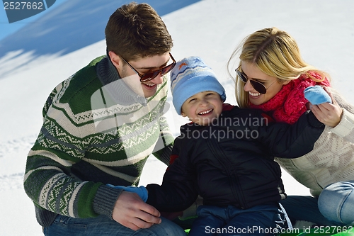 Image of family having fun on fresh snow at winter vacation