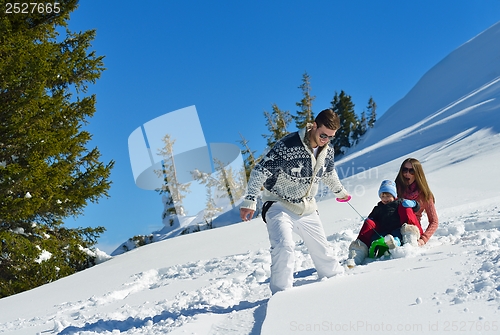 Image of family having fun on fresh snow at winter vacation