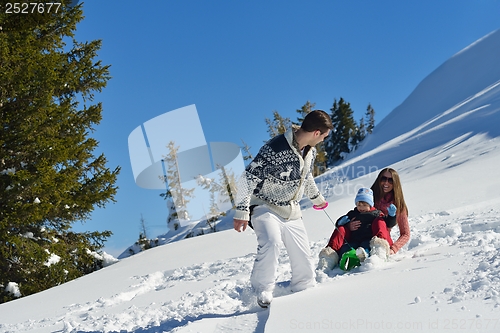 Image of family having fun on fresh snow at winter vacation