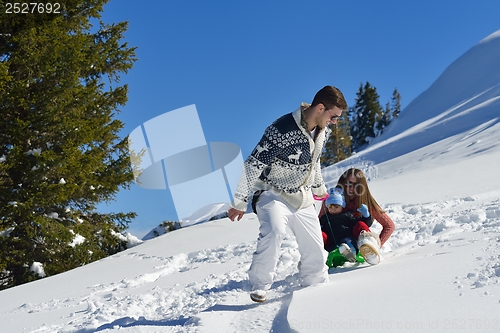 Image of family having fun on fresh snow at winter vacation