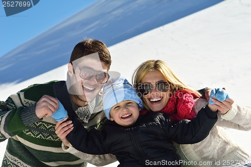 Image of family having fun on fresh snow at winter vacation