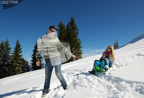 Image of family having fun on fresh snow at winter vacation