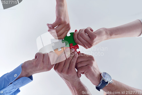 Image of Group of business people assembling jigsaw puzzle