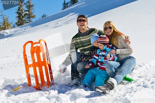 Image of family having fun on fresh snow at winter vacation