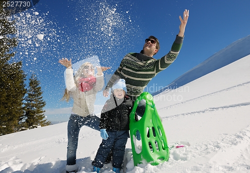 Image of family having fun on fresh snow at winter vacation