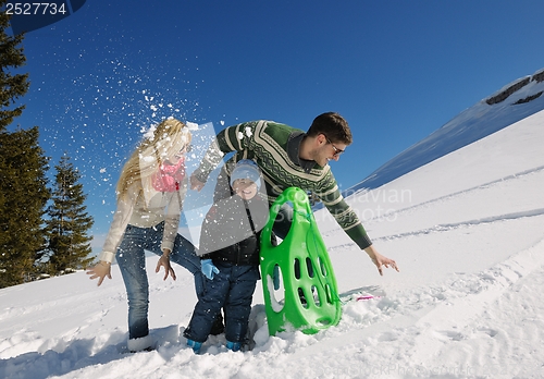 Image of family having fun on fresh snow at winter vacation