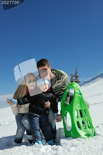 Image of family having fun on fresh snow at winter vacation