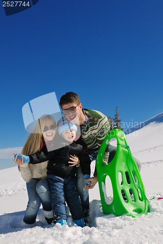 Image of family having fun on fresh snow at winter vacation