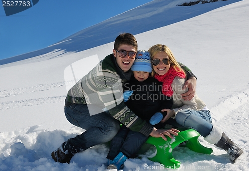 Image of family having fun on fresh snow at winter vacation