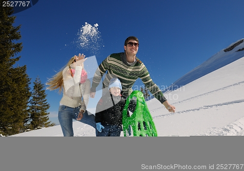 Image of family having fun on fresh snow at winter vacation