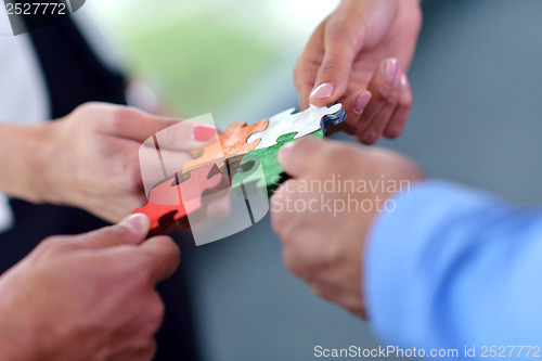 Image of Group of business people assembling jigsaw puzzle