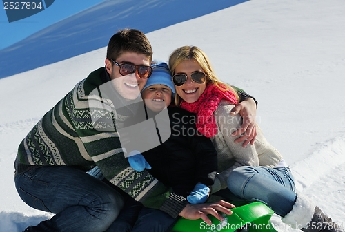 Image of family having fun on fresh snow at winter vacation