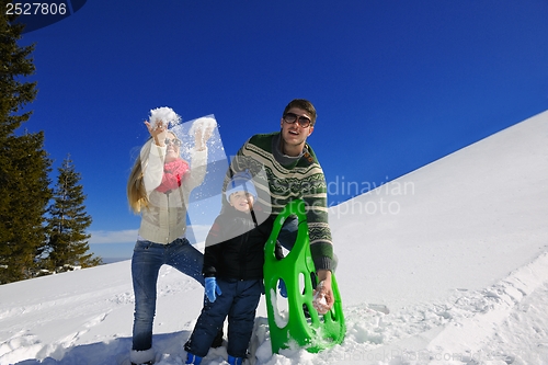 Image of family having fun on fresh snow at winter vacation