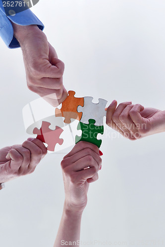 Image of Group of business people assembling jigsaw puzzle