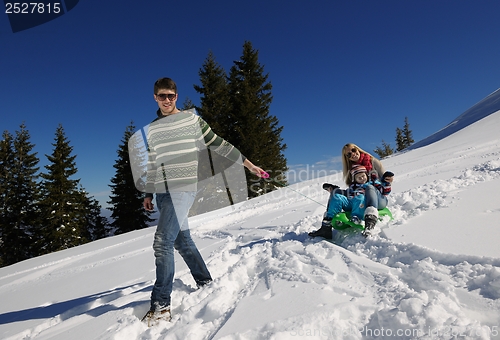 Image of family having fun on fresh snow at winter vacation