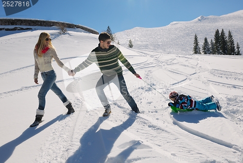 Image of family having fun on fresh snow at winter vacation