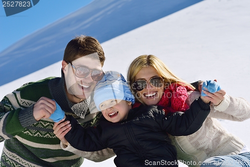 Image of family having fun on fresh snow at winter vacation