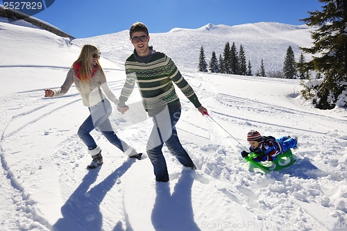 Image of family having fun on fresh snow at winter vacation