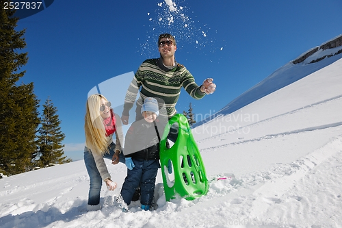 Image of family having fun on fresh snow at winter vacation