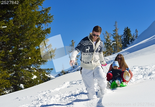 Image of family having fun on fresh snow at winter vacation