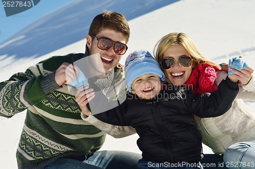 Image of family having fun on fresh snow at winter vacation