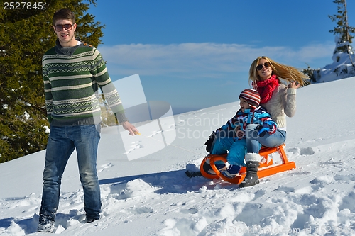 Image of family having fun on fresh snow at winter vacation