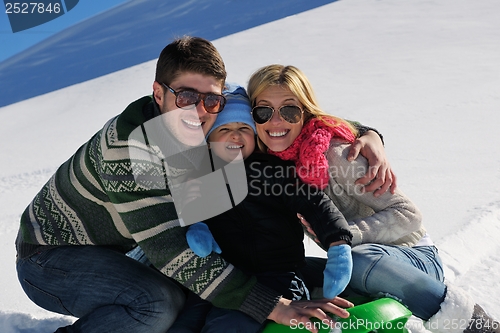 Image of family having fun on fresh snow at winter vacation