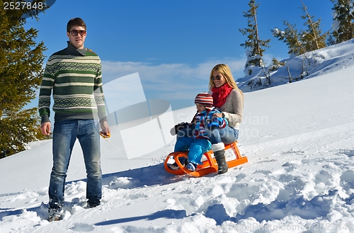 Image of family having fun on fresh snow at winter vacation