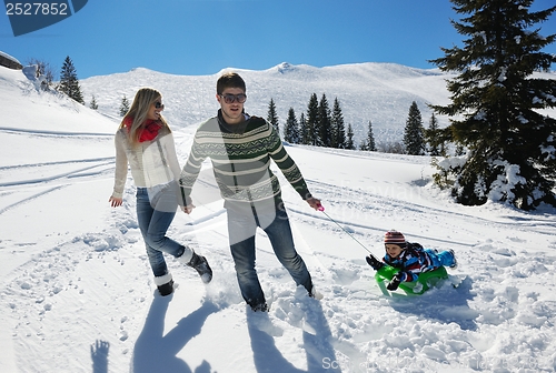 Image of family having fun on fresh snow at winter vacation