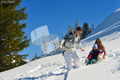Image of family having fun on fresh snow at winter vacation