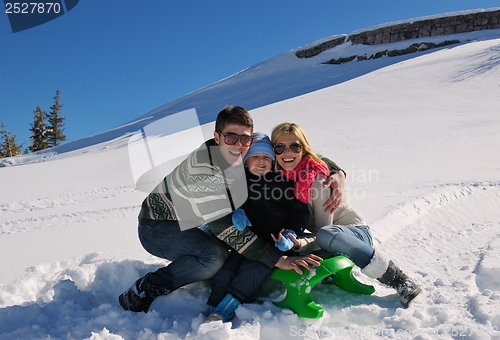 Image of family having fun on fresh snow at winter vacation