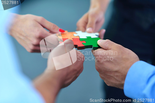 Image of Group of business people assembling jigsaw puzzle