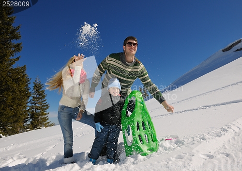 Image of family having fun on fresh snow at winter vacation