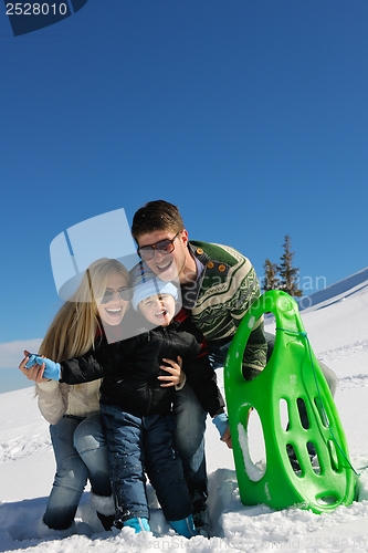 Image of family having fun on fresh snow at winter vacation