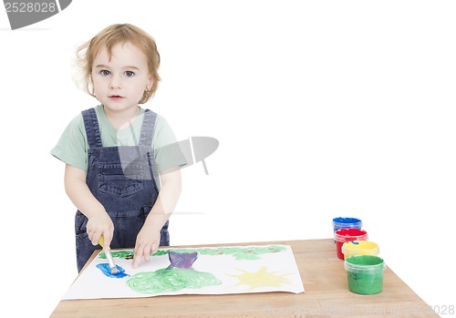 Image of cute girl painting on small desk
